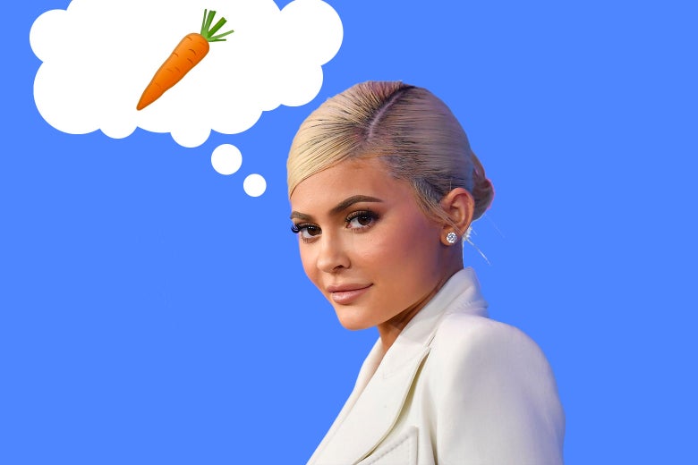 Kylie Jenner in front of a blue background thinking of a single carrot.